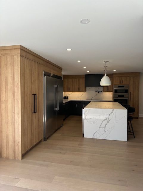 A kitchen with stainless steel appliances and wooden cabinets