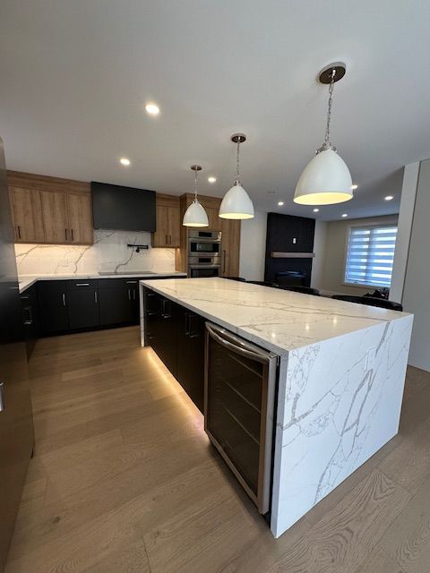 A kitchen with a large island and stainless steel appliances