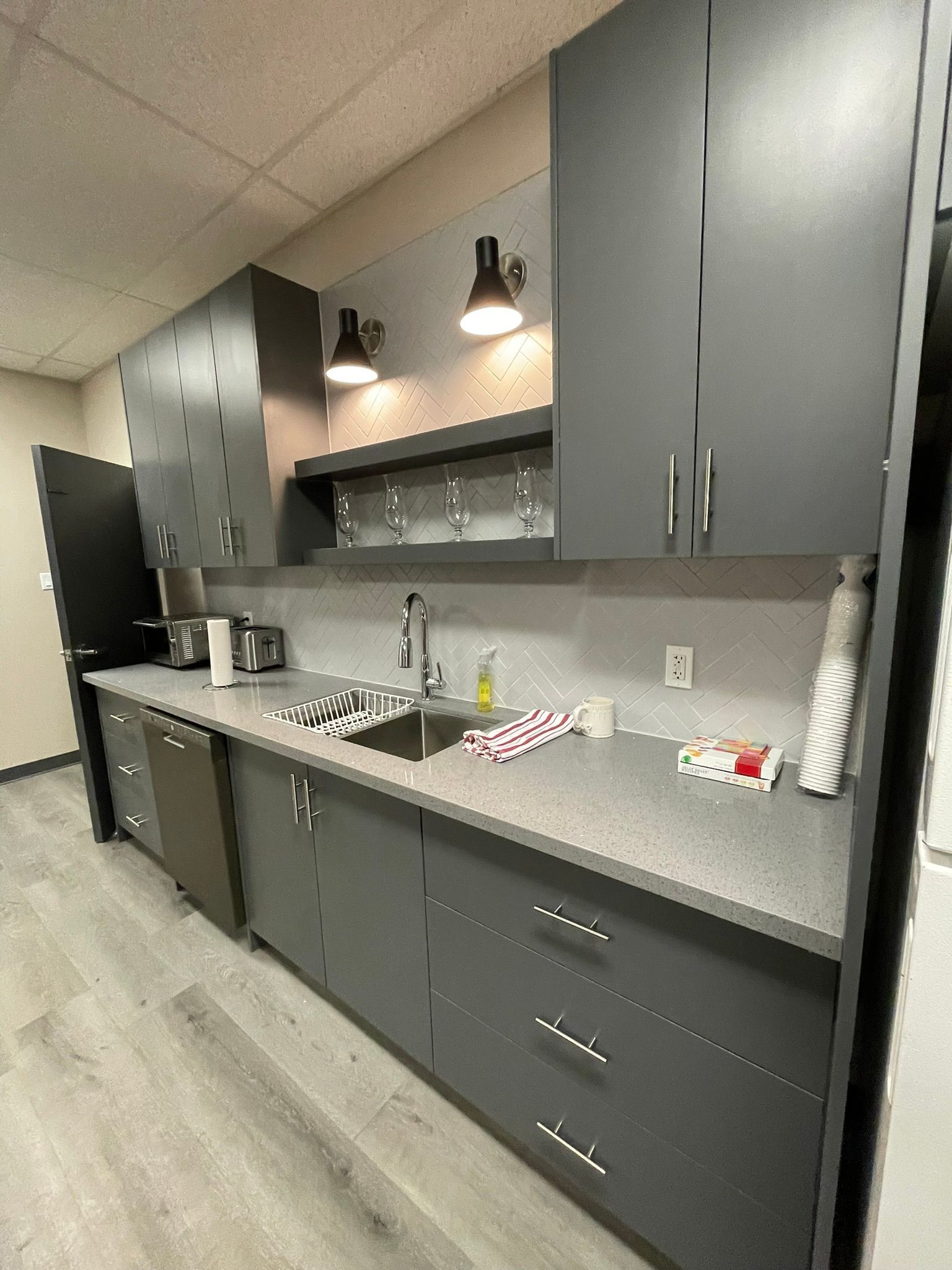 Modern kitchen with gray cabinets, sink, and appliances.