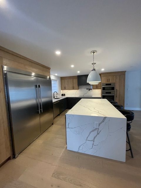 A kitchen with a large island and stainless steel appliances