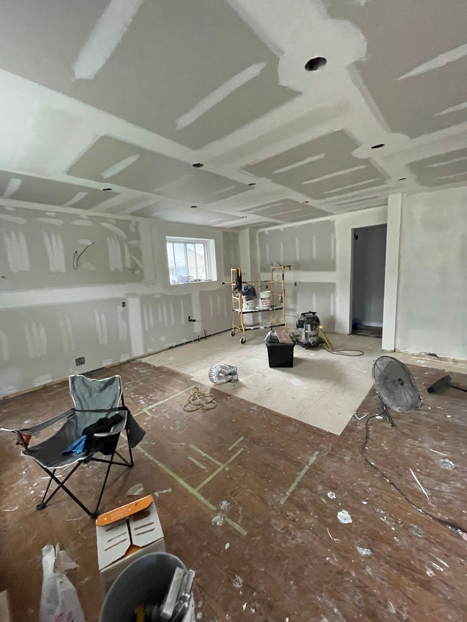 A room with a lot of drywall and a chair in it.