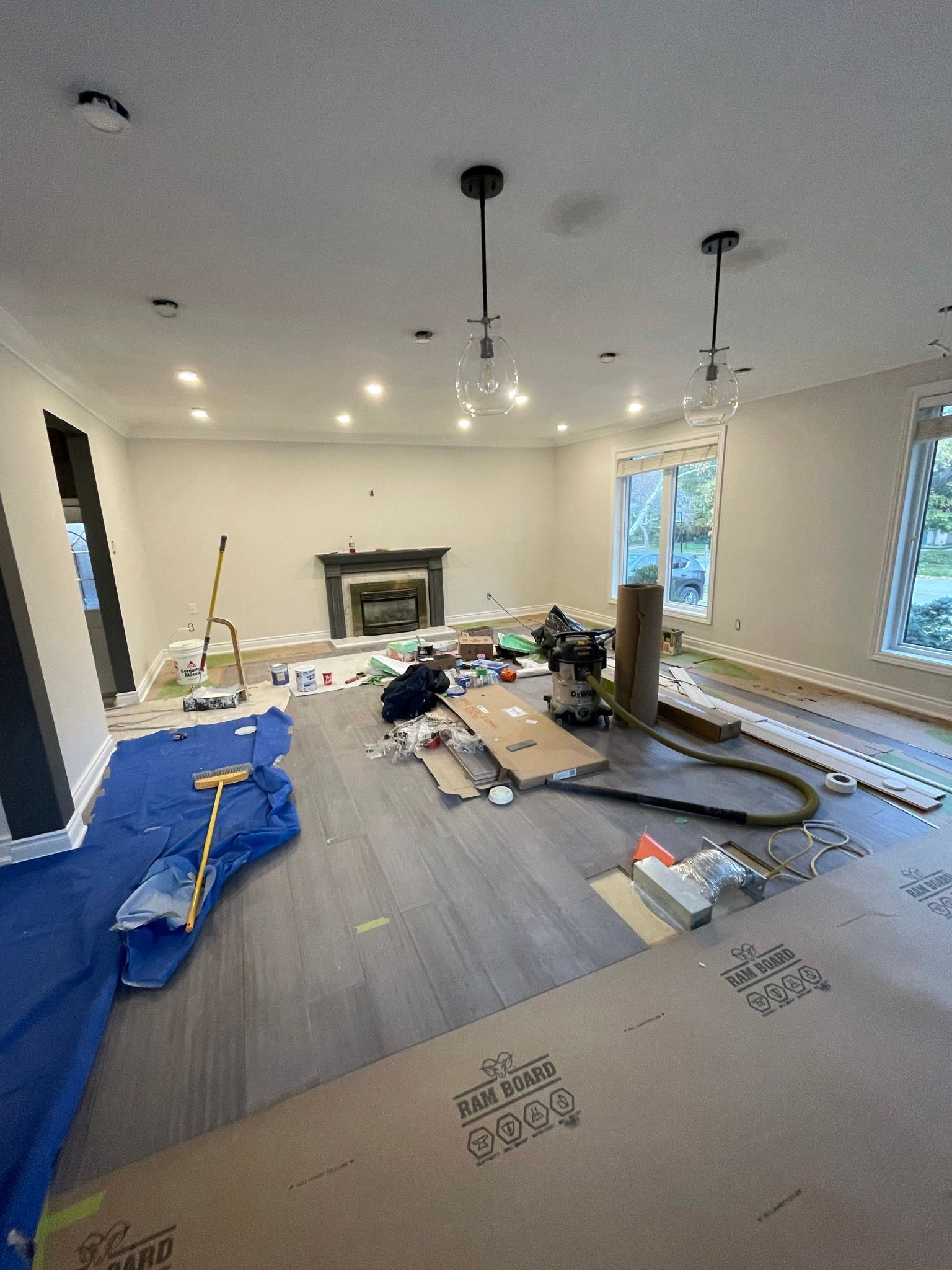 A living room with a fireplace and a lot of boxes on the floor.