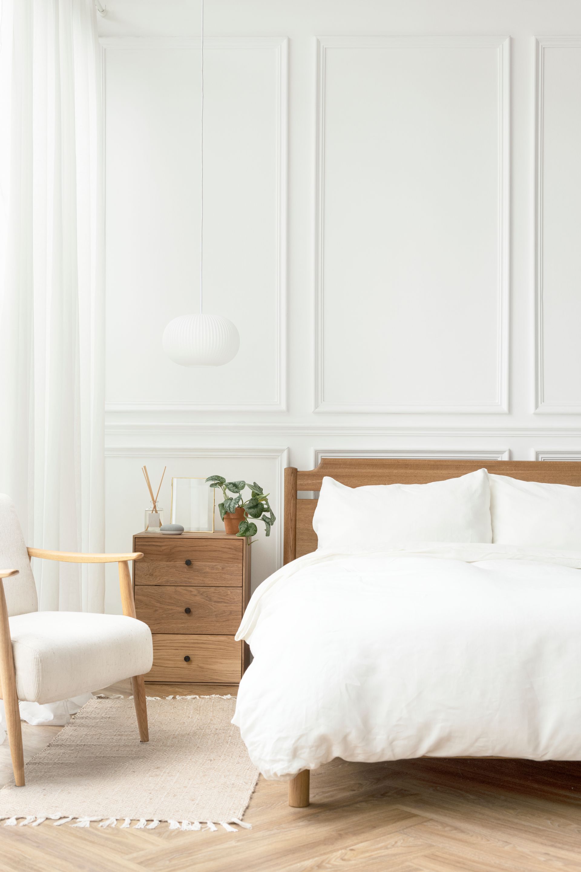 A bedroom with a bed , chair , nightstand and dresser.