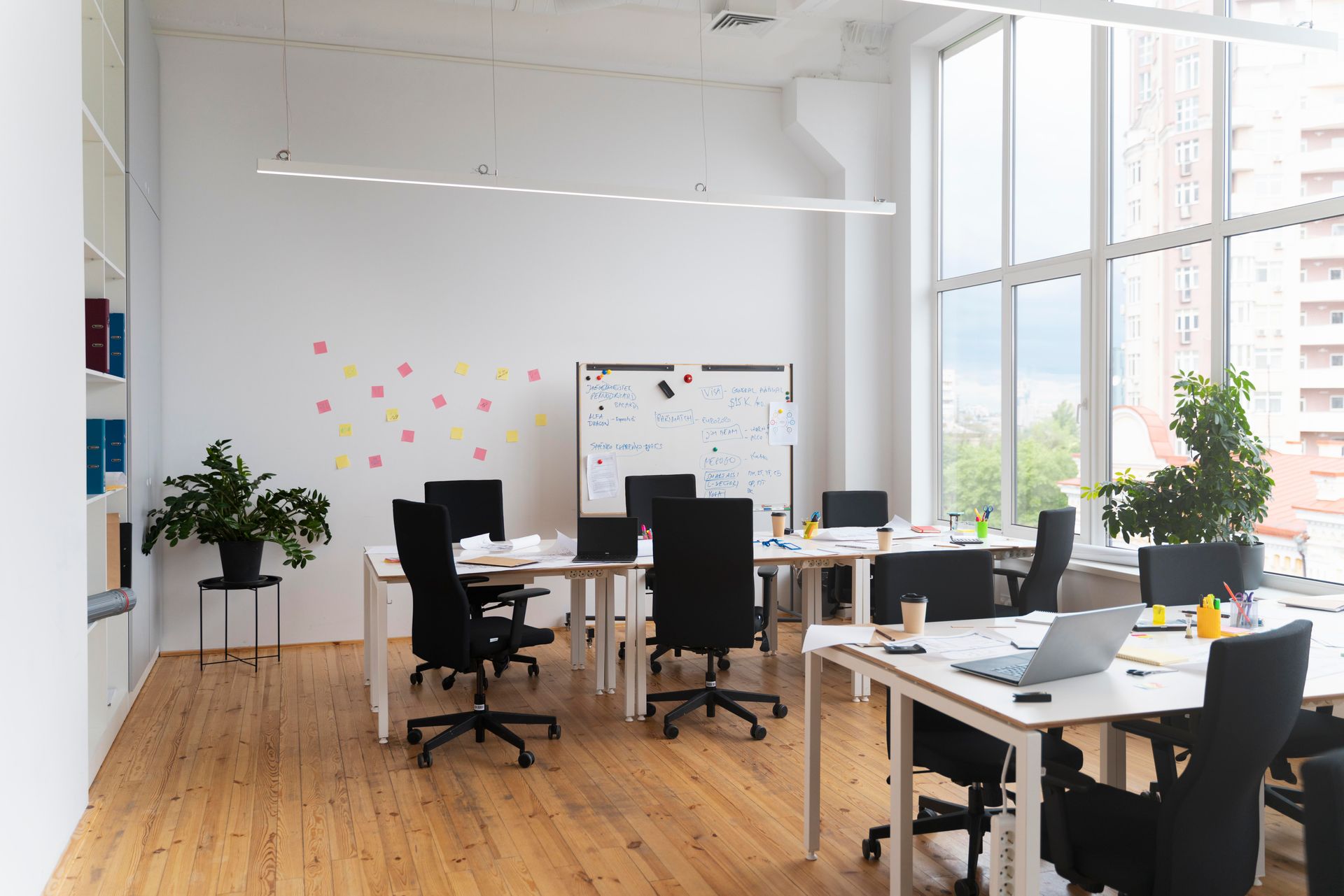 An empty office with tables and chairs and a whiteboard.