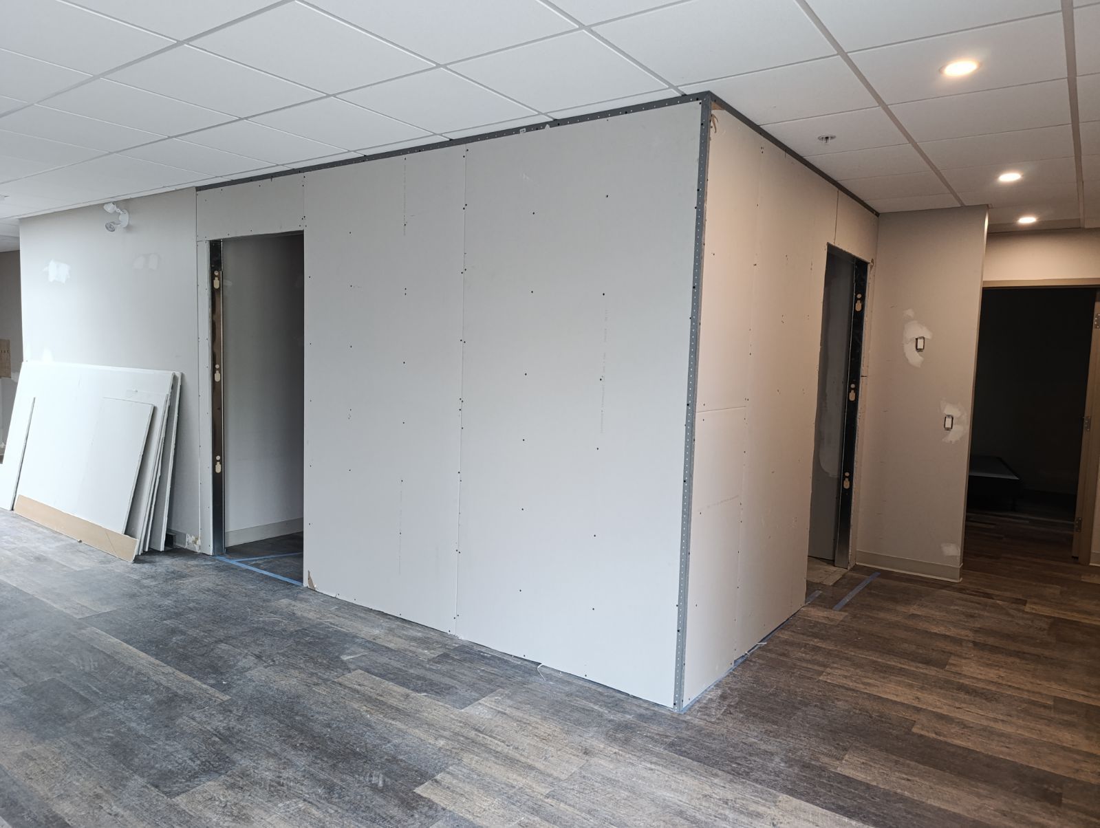 Interior construction: Drywall walls with doorways, wood-look flooring, and a drop ceiling.