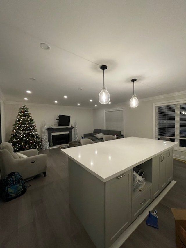 A living room with a christmas tree and a large island in the middle.