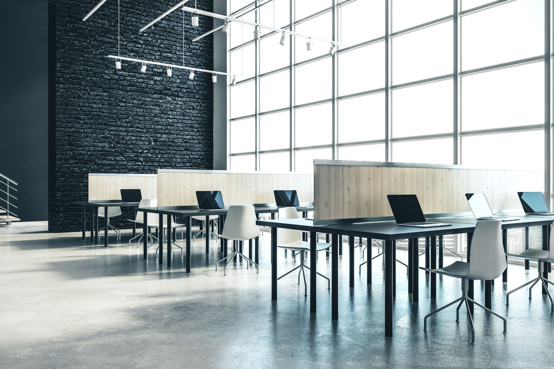 A row of tables and chairs in an office with lots of windows.