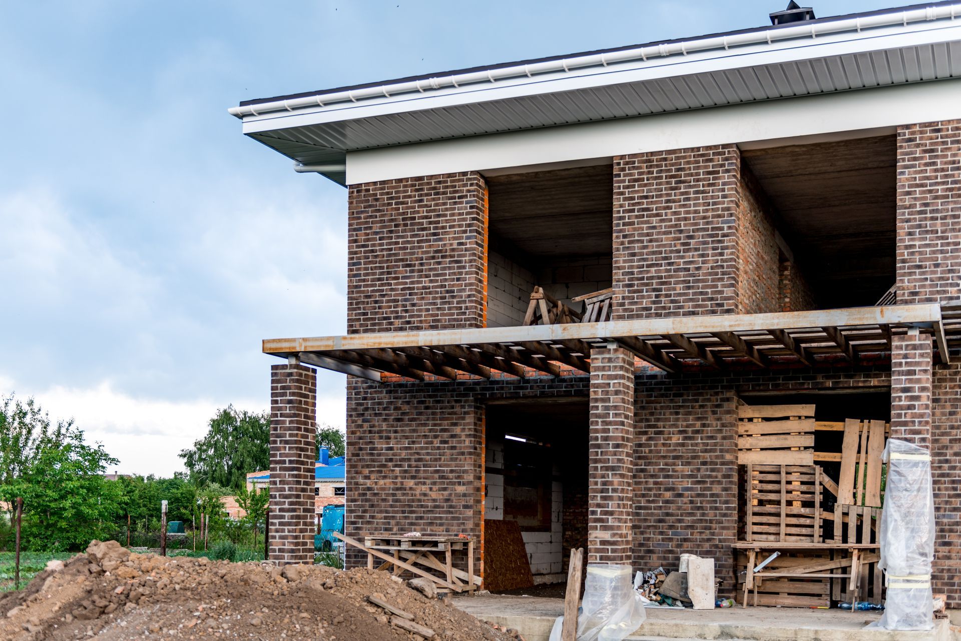 A brick house is being built in a rural area.