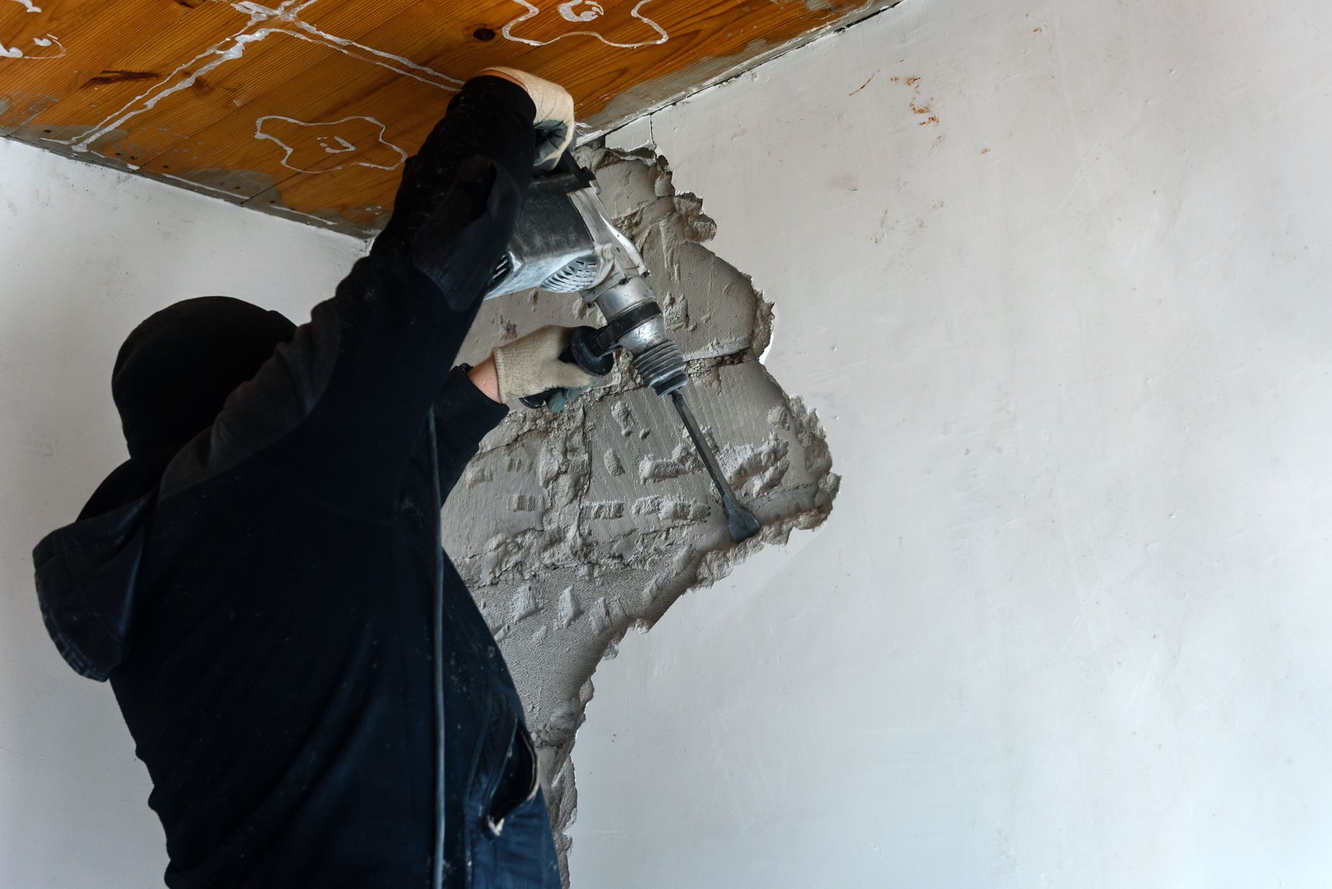 A man is using a drill to drill a hole in a wall.