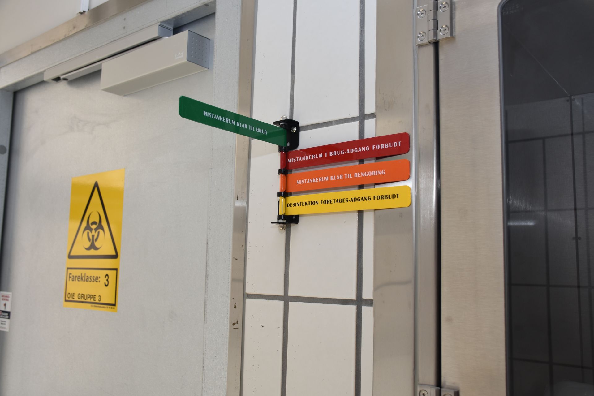 Door with biohazard symbol and color-coded safety signs.