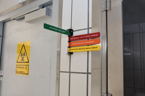 Door with biohazard symbol and color-coded safety signs.