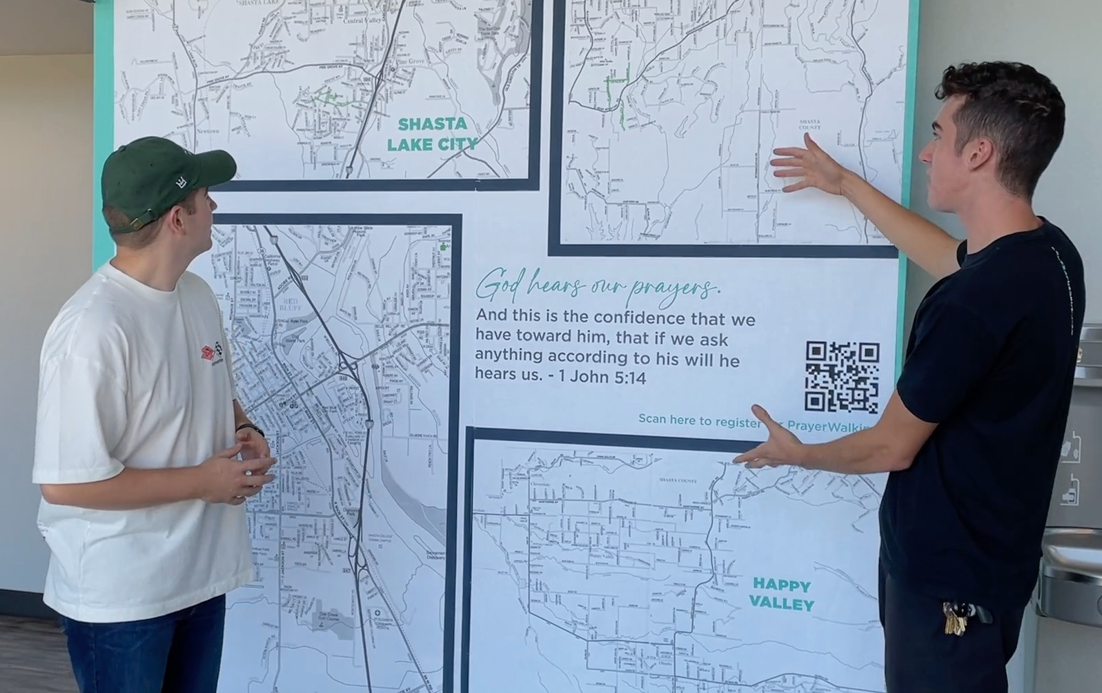 Two men are standing in front of a large map.
