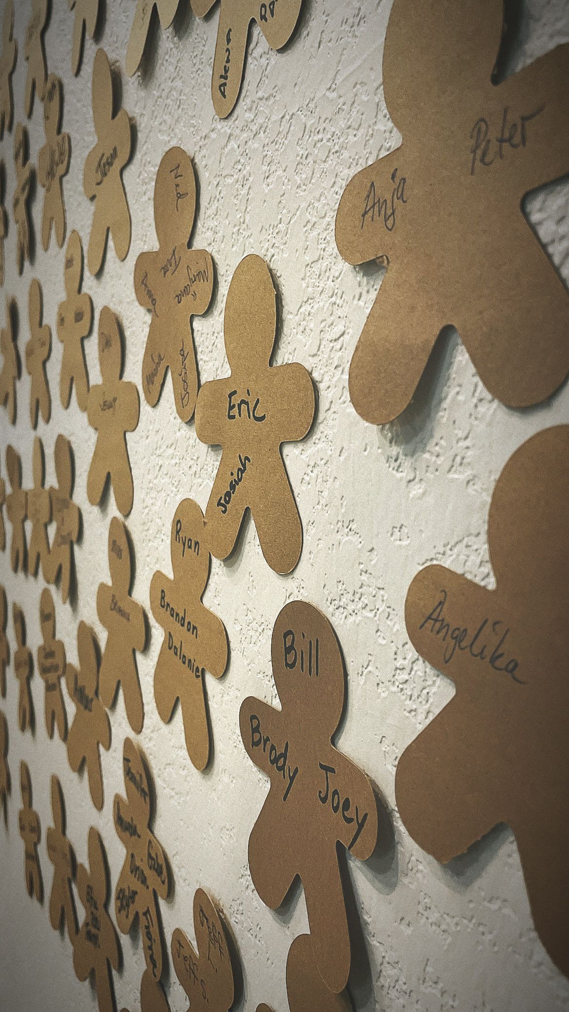 A wall filled with gingerbread men with names on them