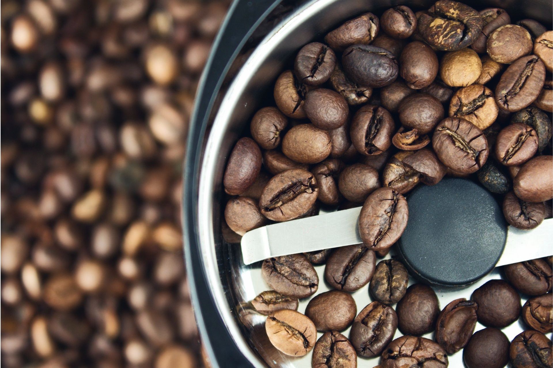 A close up of a coffee grinder filled with coffee beans.