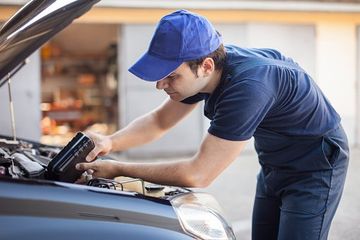 Mechanic putting oil in a car engine - Auto Repair Shop in Fredericksburg, VA