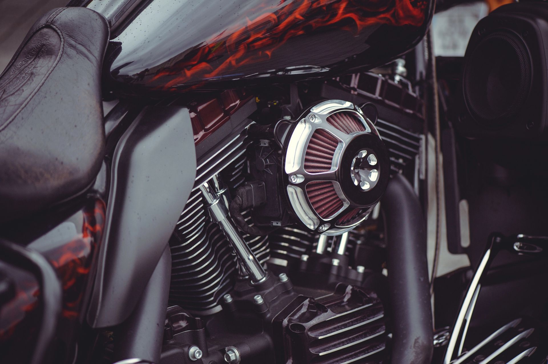 Primo piano di un motore di motocicletta con dettagli cromati e accenti rossi.