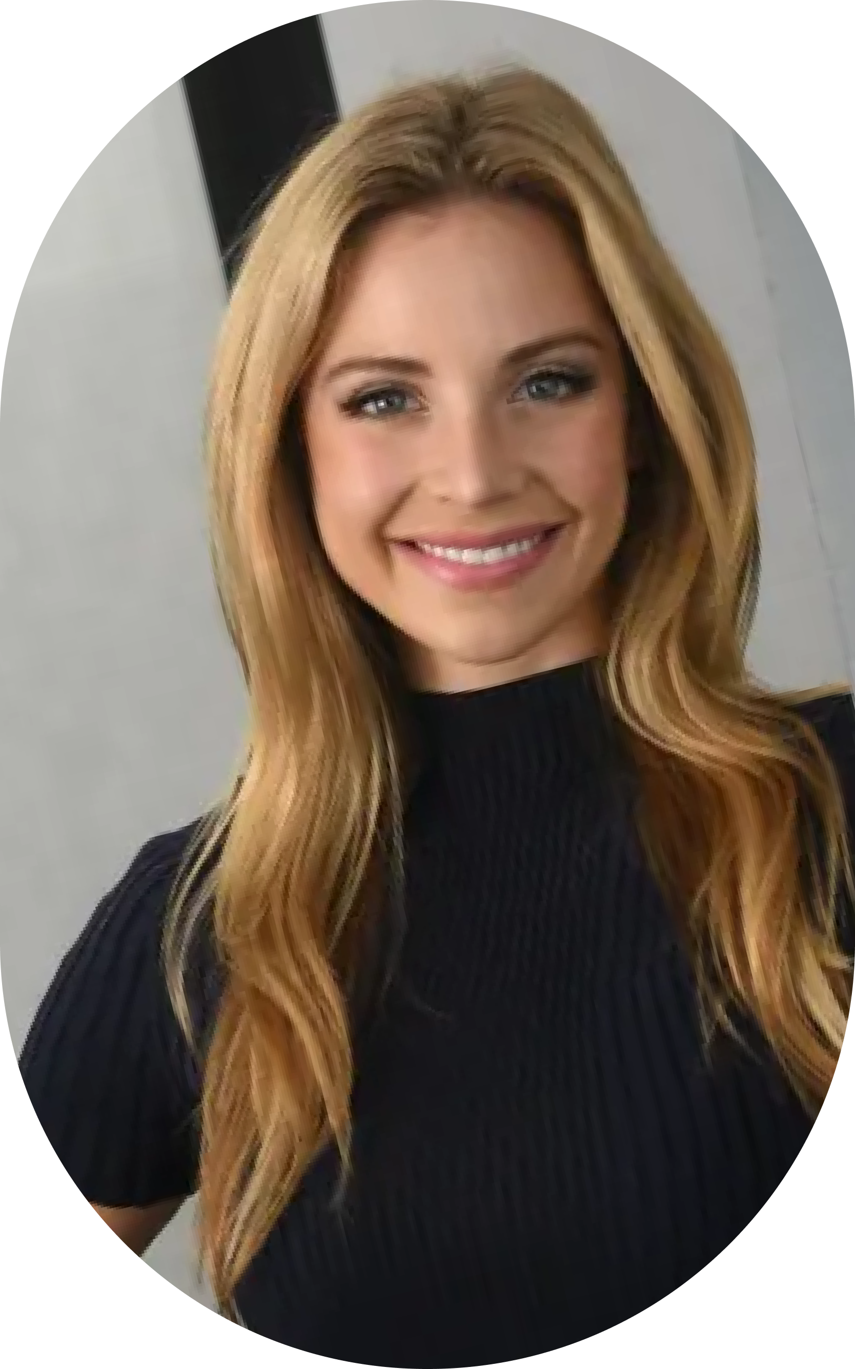 A woman with long blonde hair is smiling and wearing a black sweater