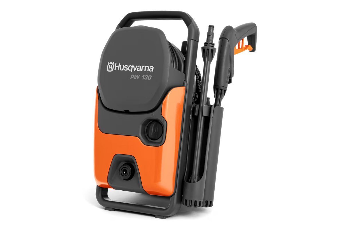 Husqvarna pressure washer, orange and black, with stored accessories.
