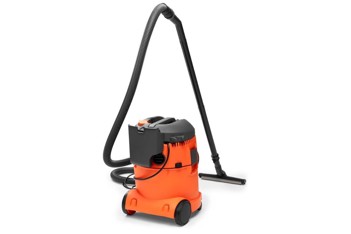 Orange and black shop vacuum with hose and floor attachment.