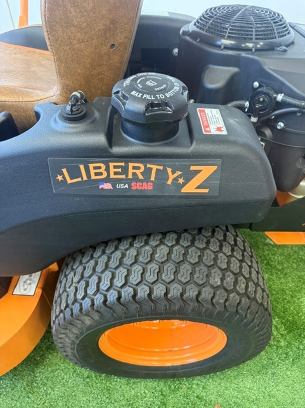 Liberty Z zero-turn lawn mower with orange wheel on artificial grass