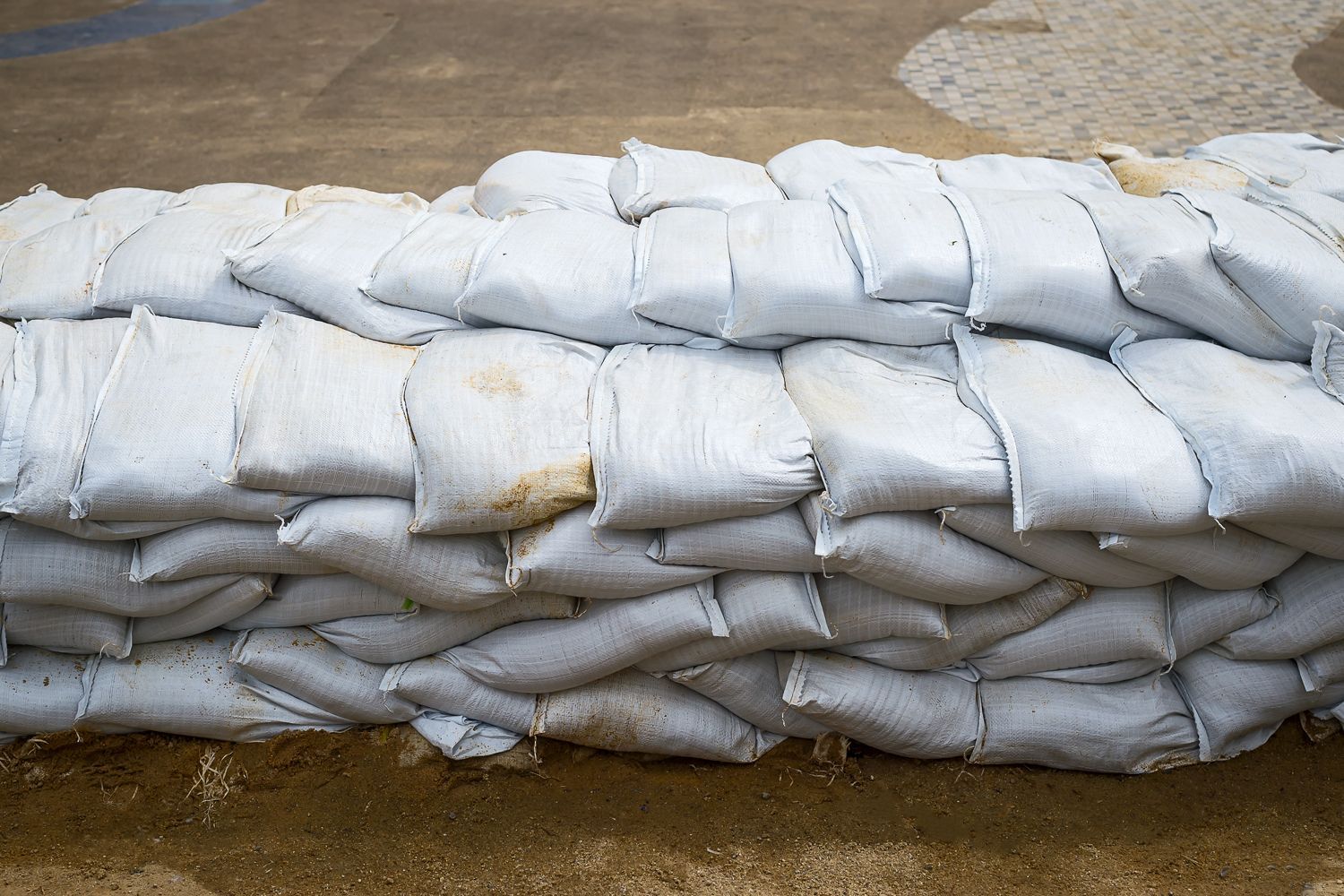 a pile of filled sandbags stacked on top of each other to prevent flood damage