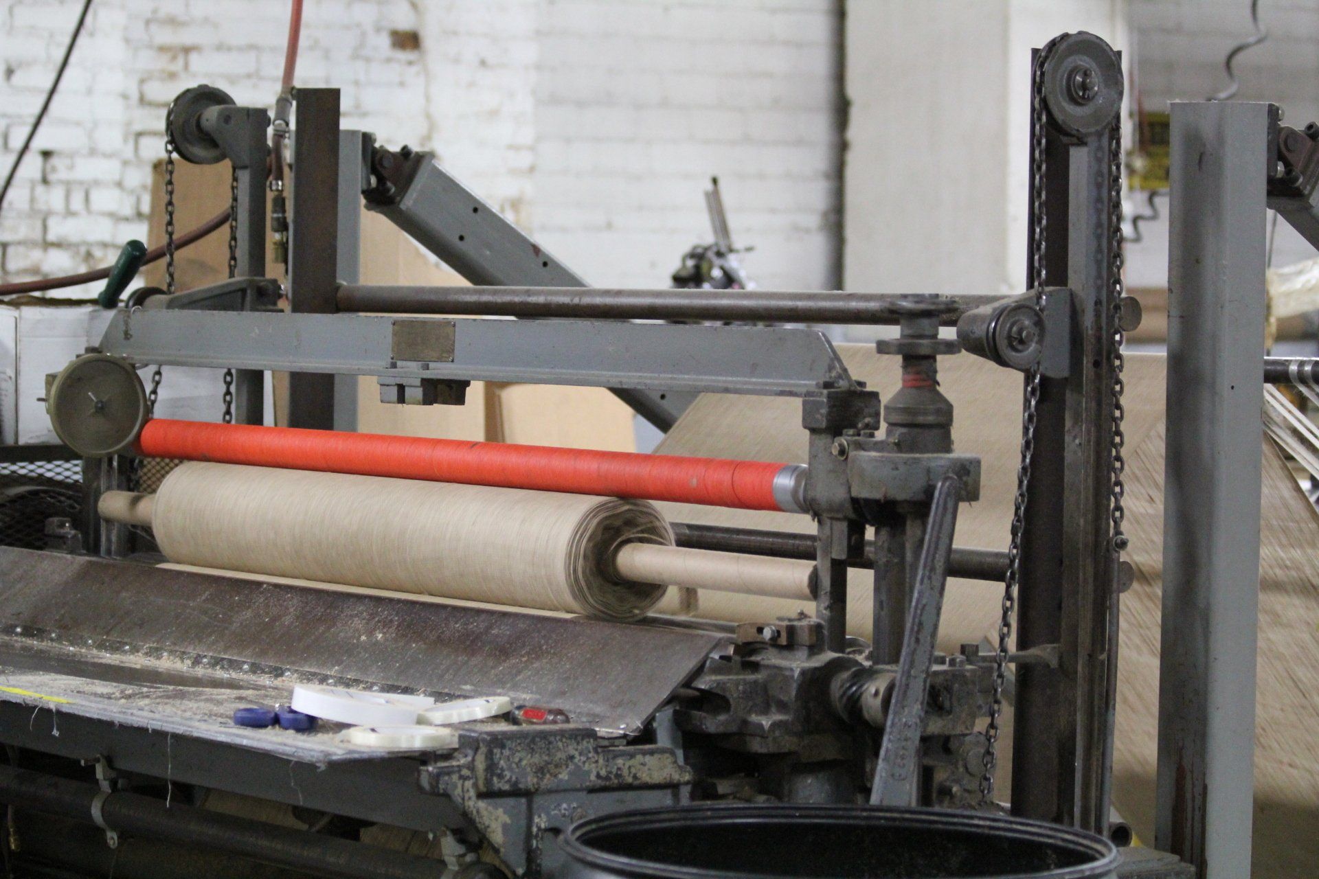 A machine unraveling a roll of burlap.