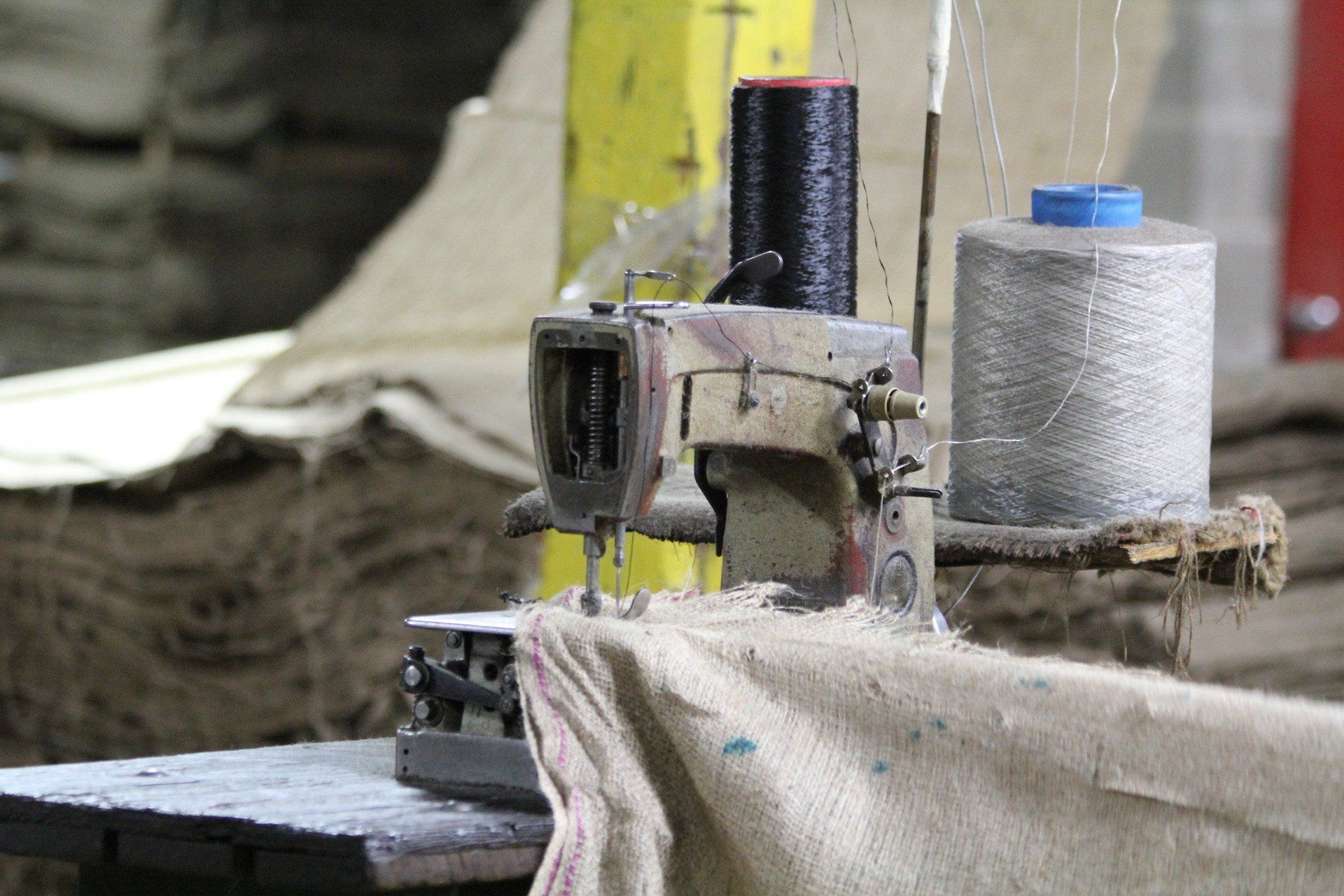 A sewing machine working with burlap fabric.