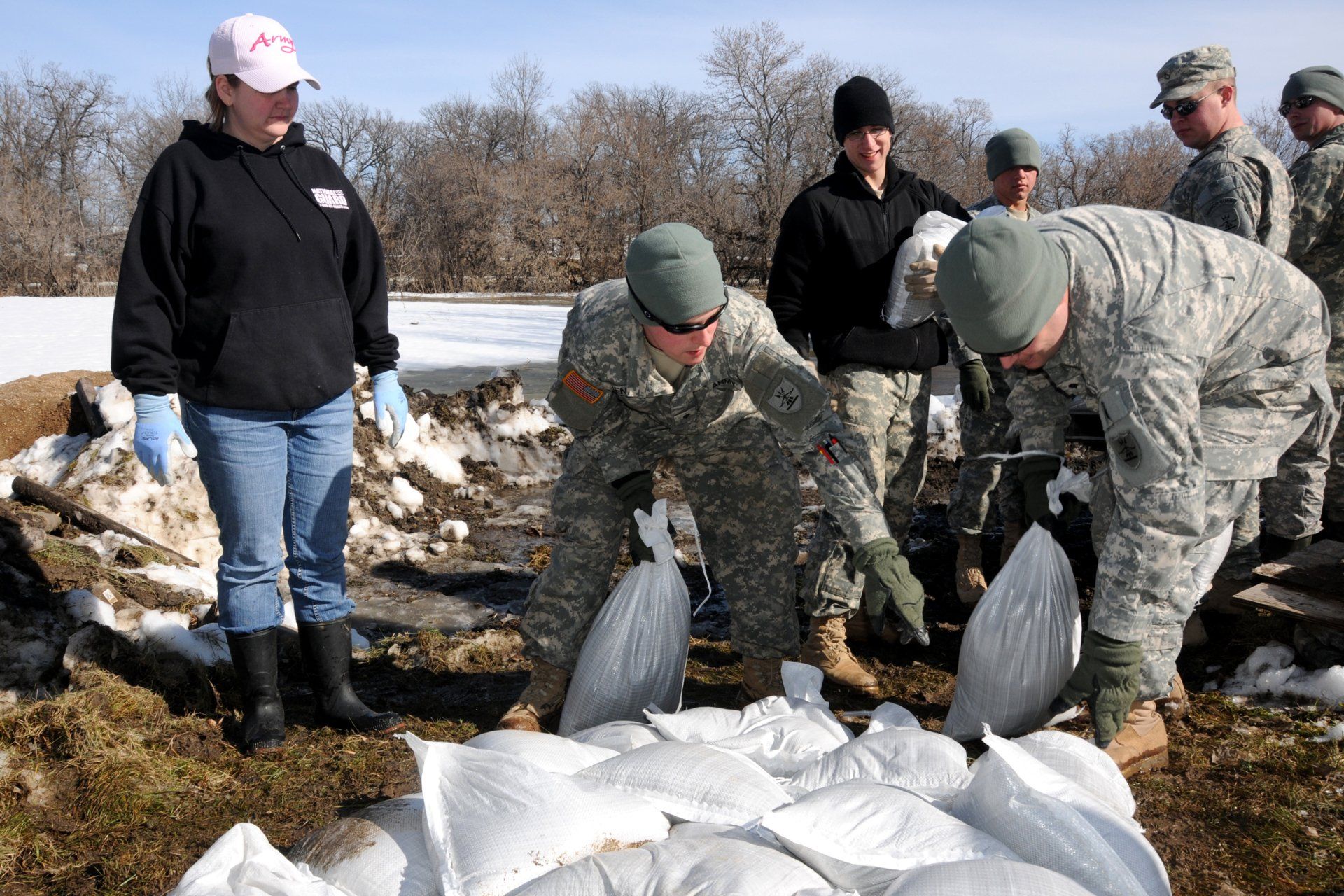 Men setting down sandbags.