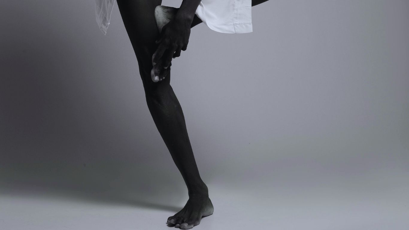 African man standing on one leg