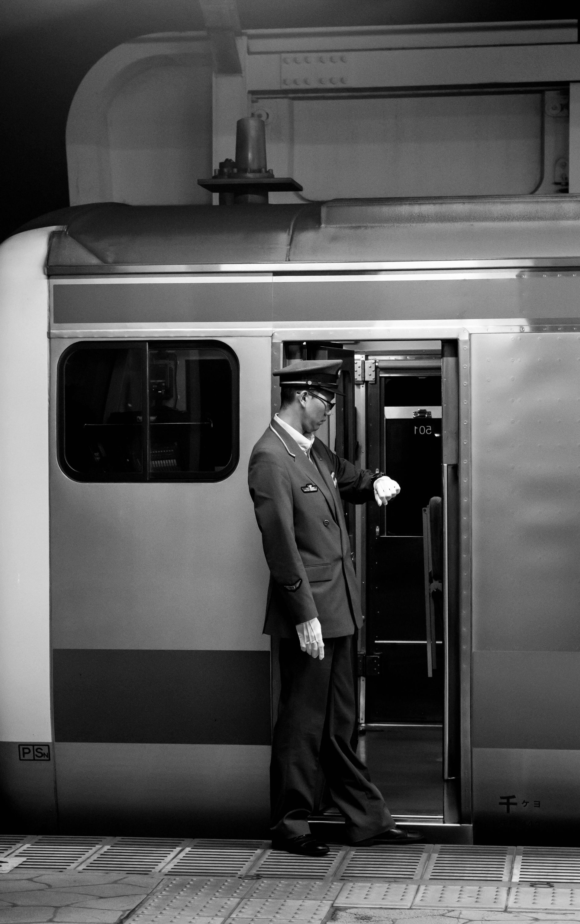 A man at a train station waiting for the train doors to close