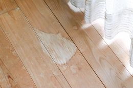 A wooden floor with a white curtain behind it