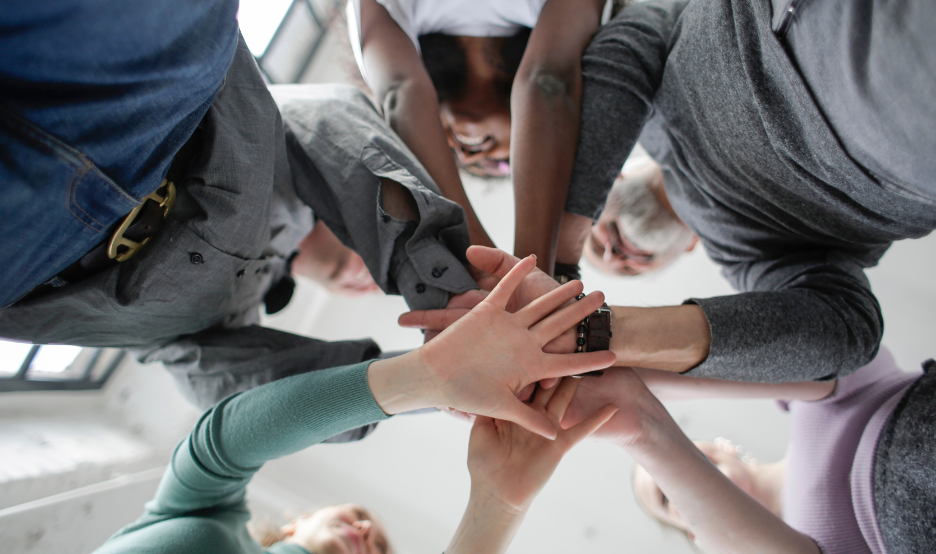 group of people putting hands together 