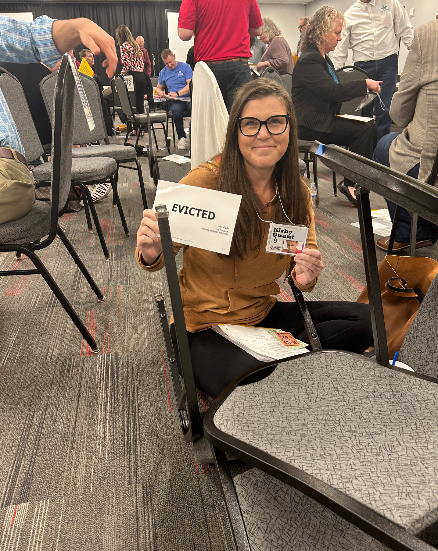 A girl sitting on the ground holding an eviction notice in a poverty simulation 