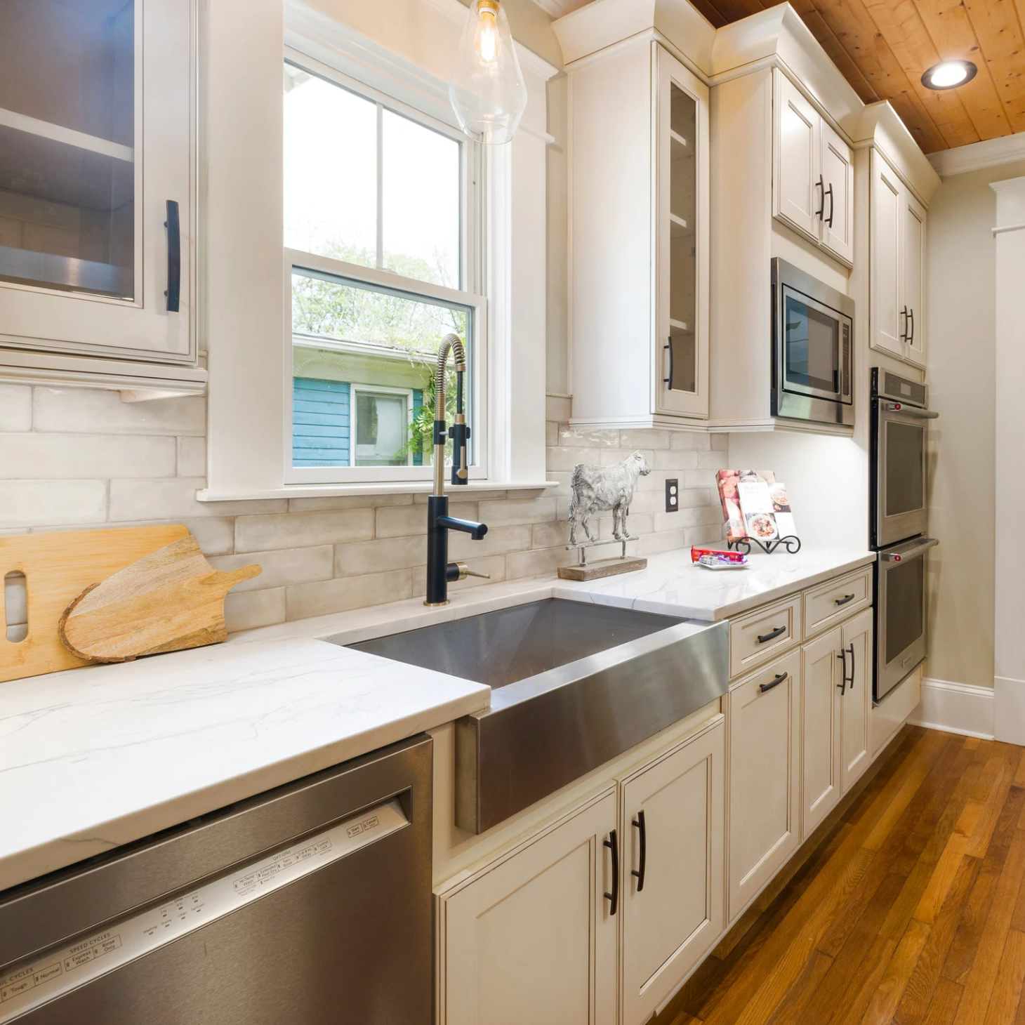 A kitchen with white cabinets and a stainless steel sink