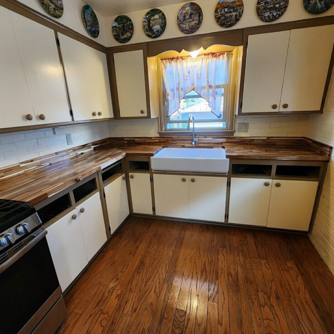 A kitchen with wooden floors and white cabinets