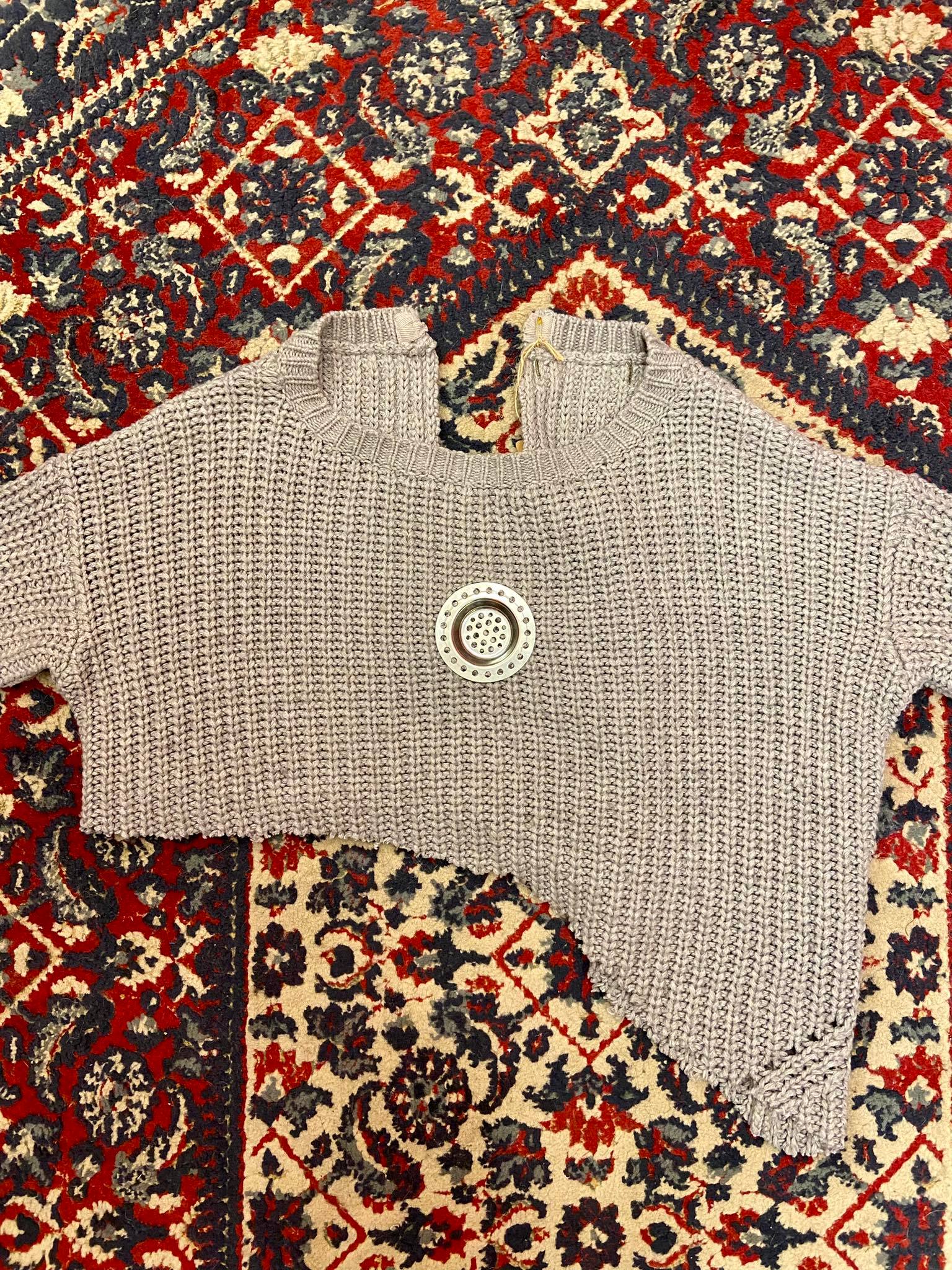 Camisola upcycled com um aplique metálico.