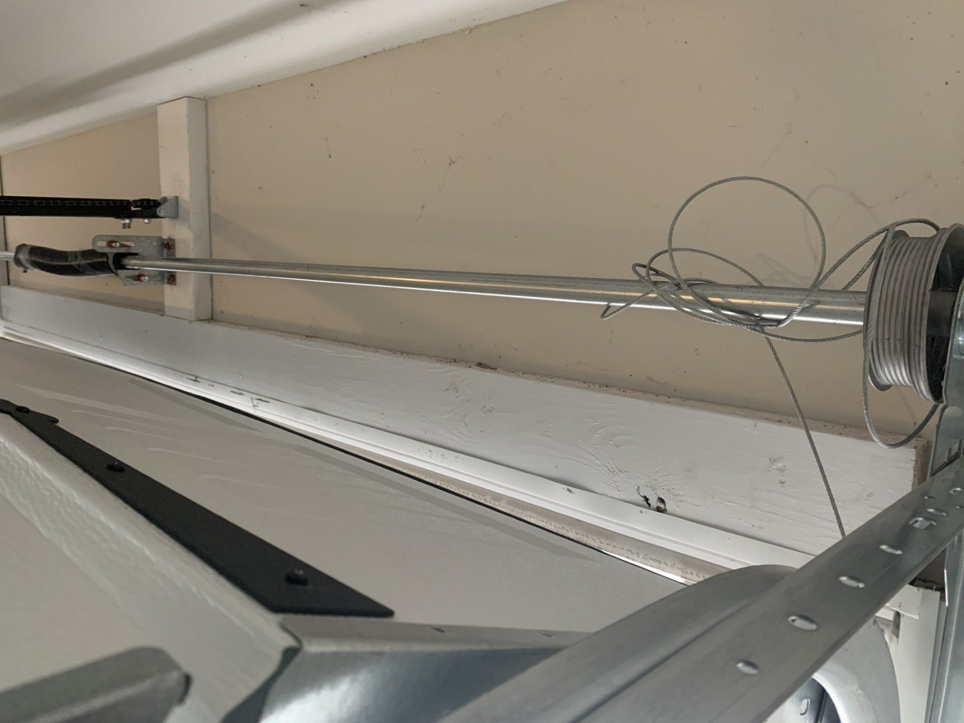 A close up of a garage door with a wire hanging from it.