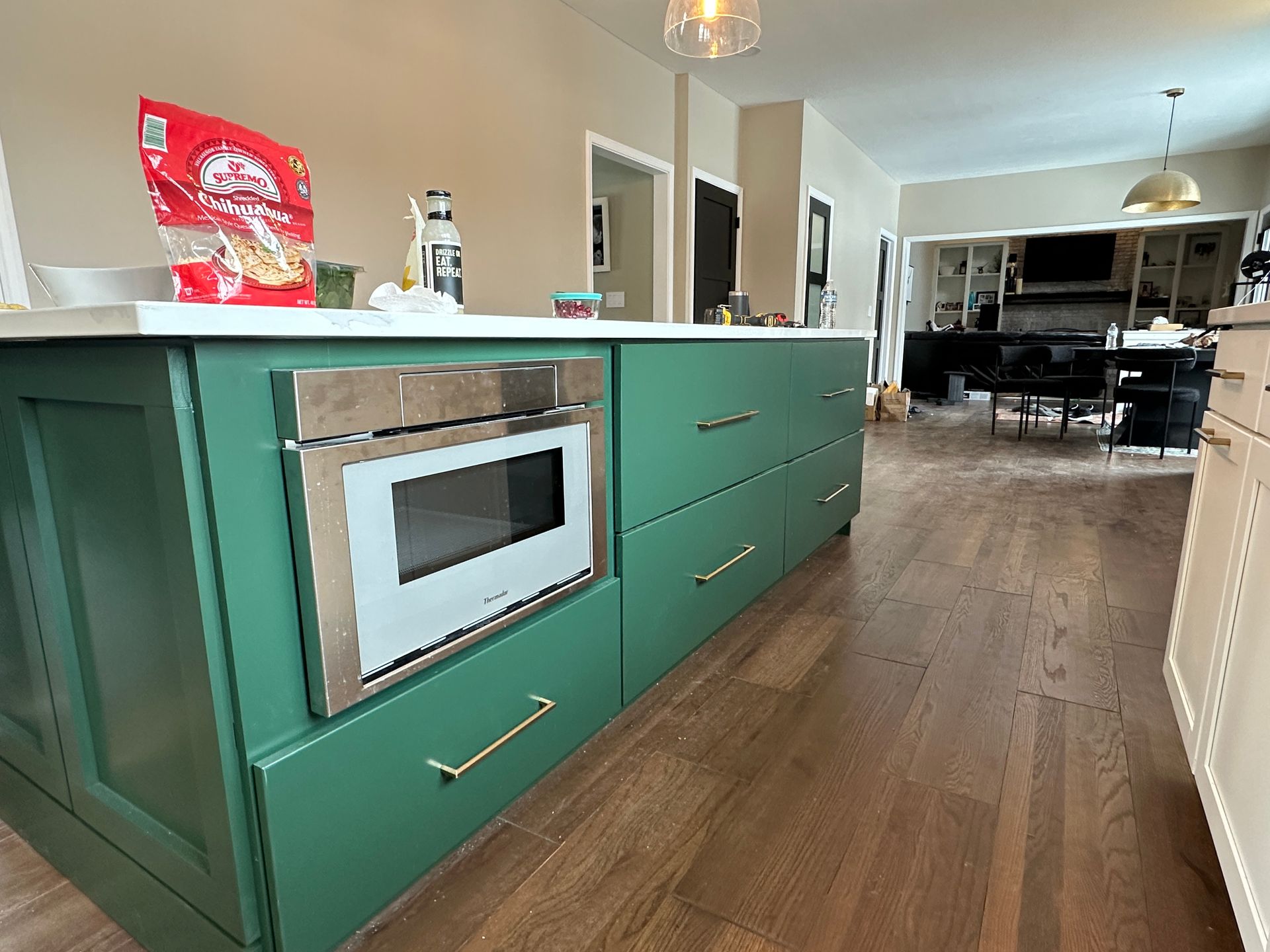 A kitchen with green cabinets and a white microwave oven.