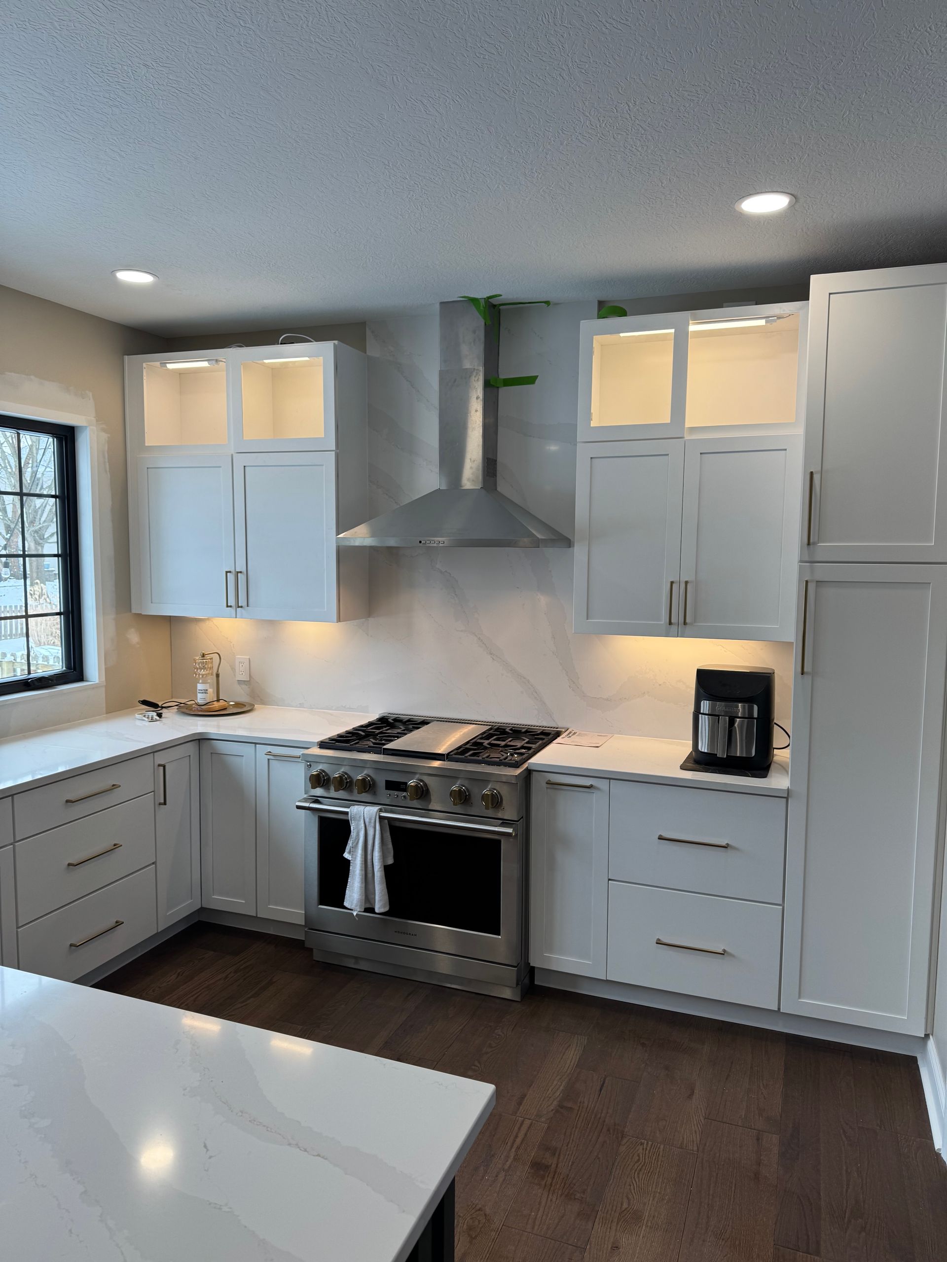 A kitchen with white cabinets and stainless steel appliances