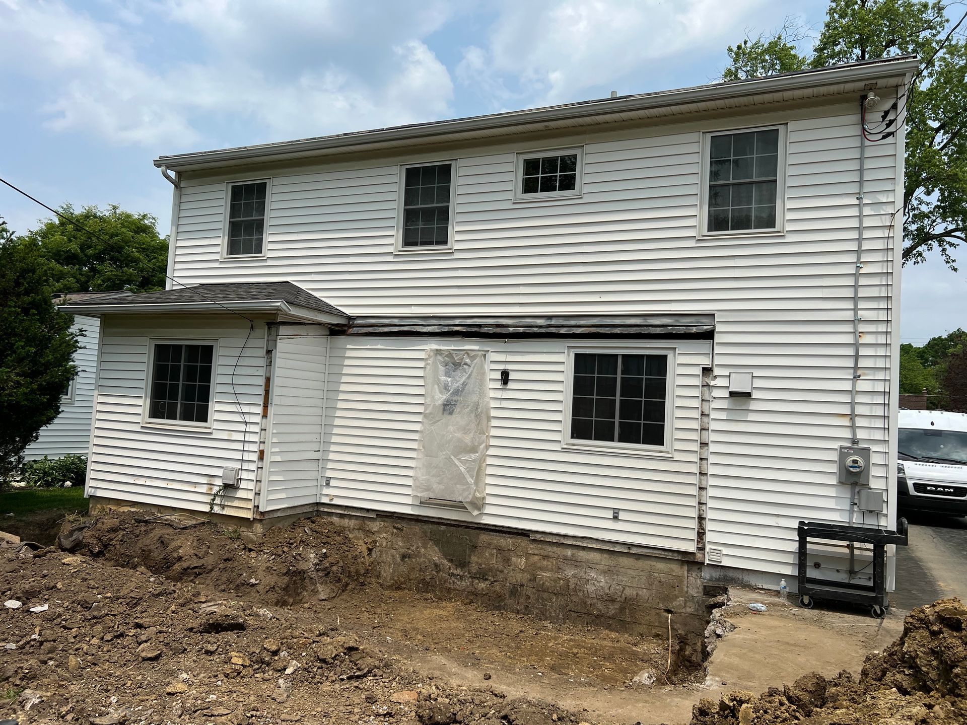 A white house with a lot of dirt in front of it