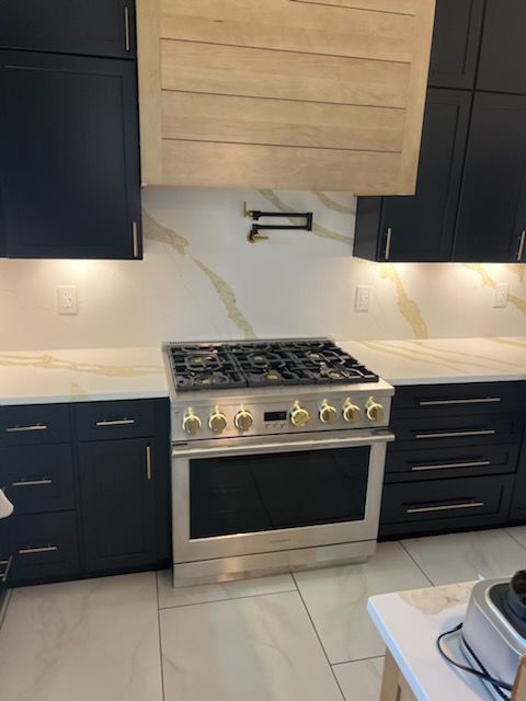 A kitchen with black cabinets and a stove top oven.