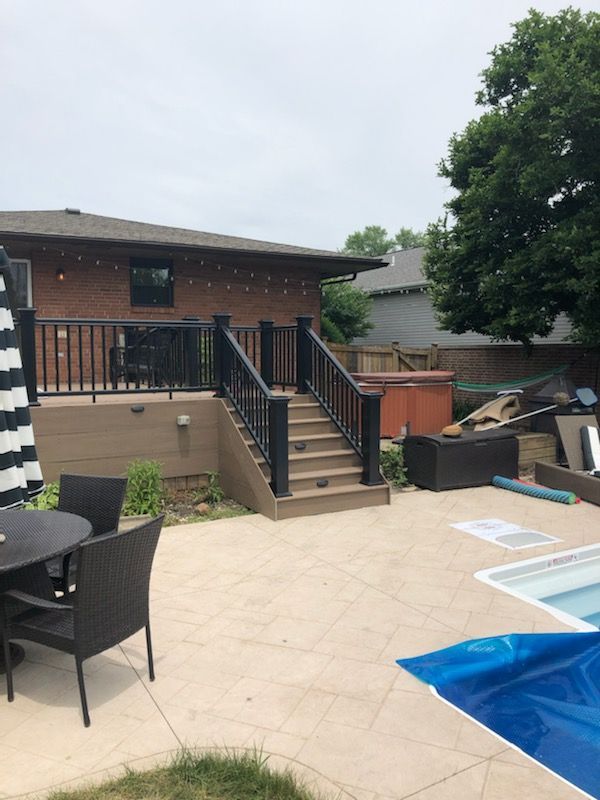 A patio with a table and chairs next to a swimming pool.