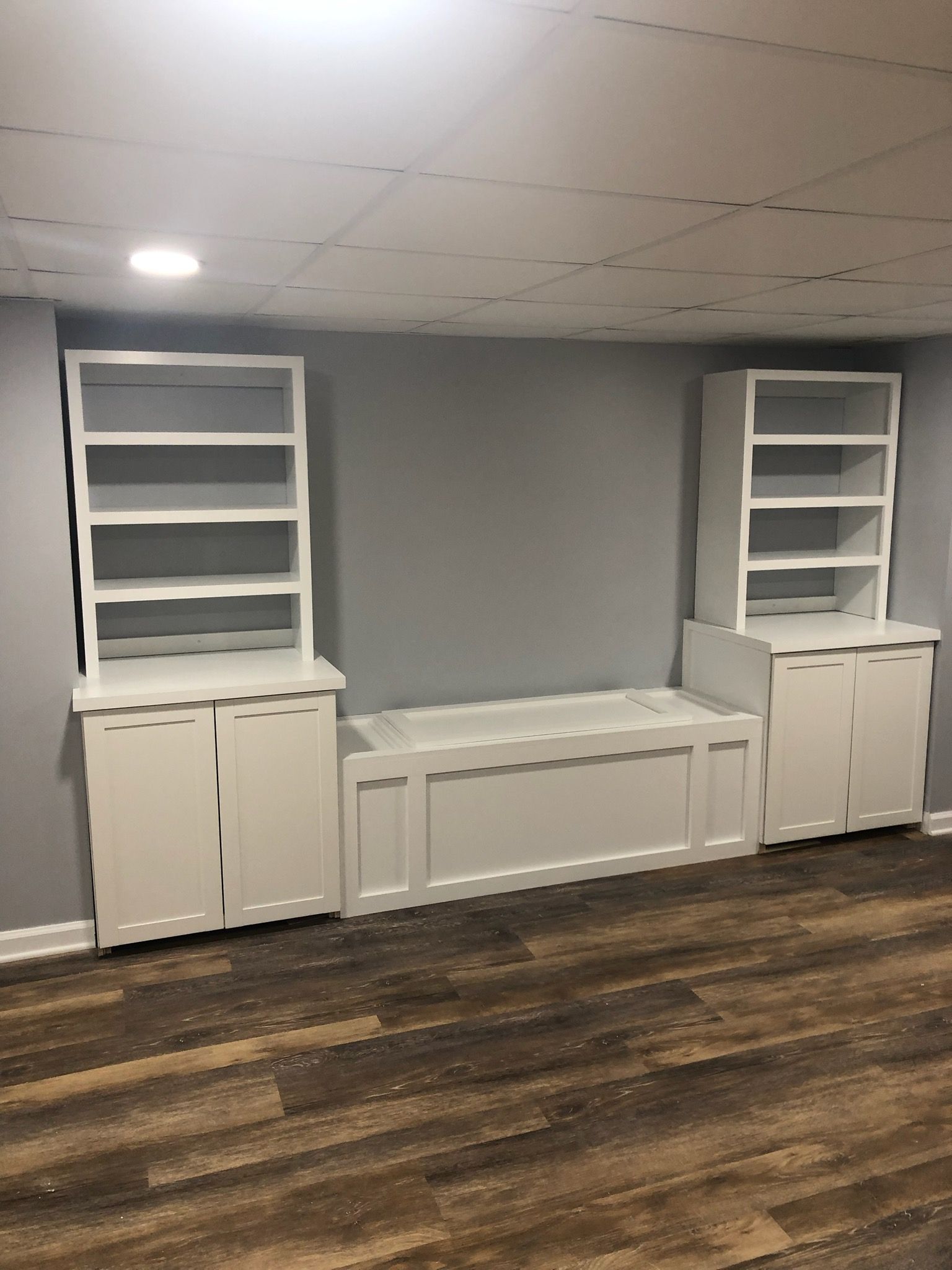 A room with a bench and shelves in it.