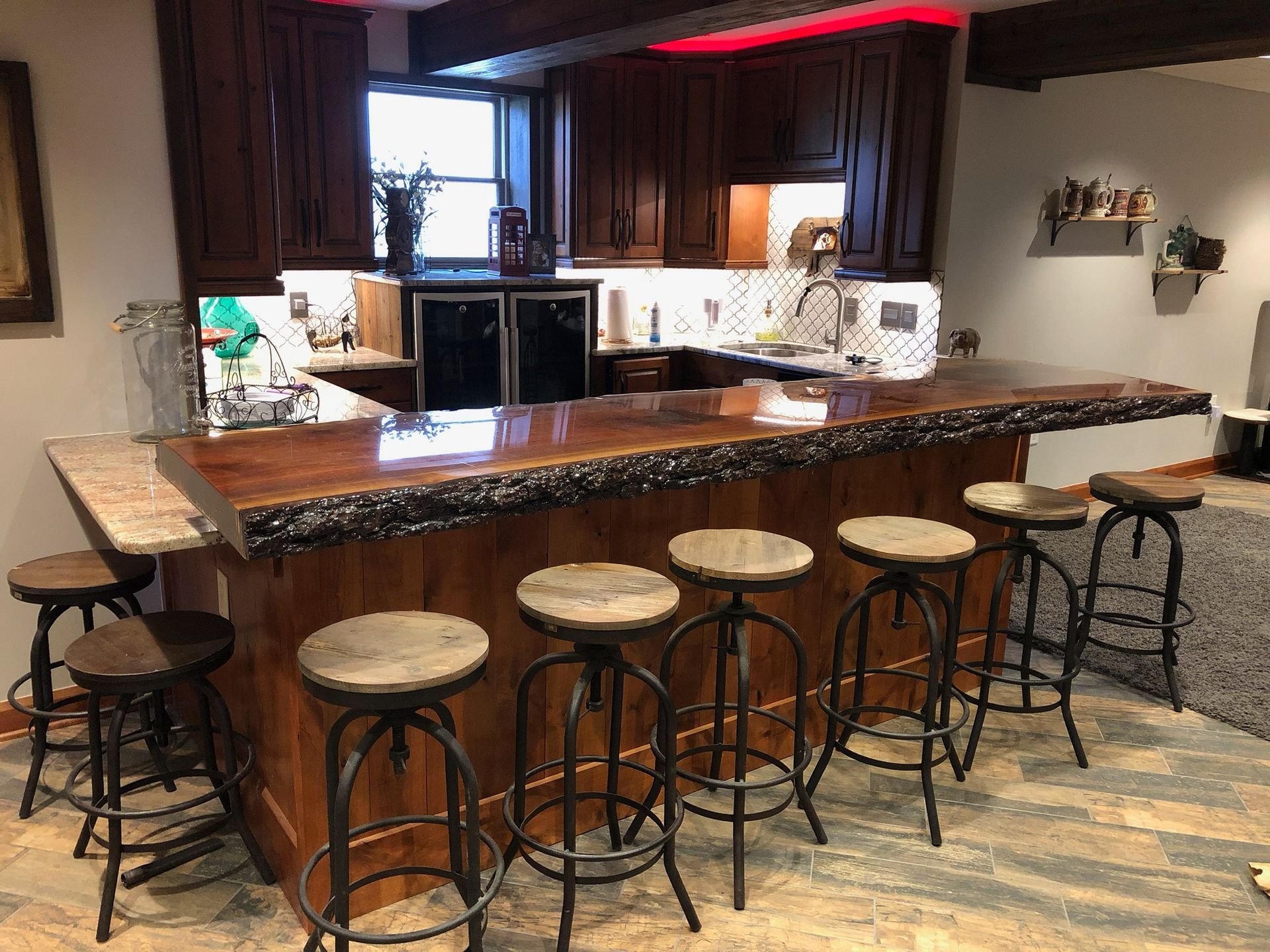 A kitchen with a bar and stools in it.