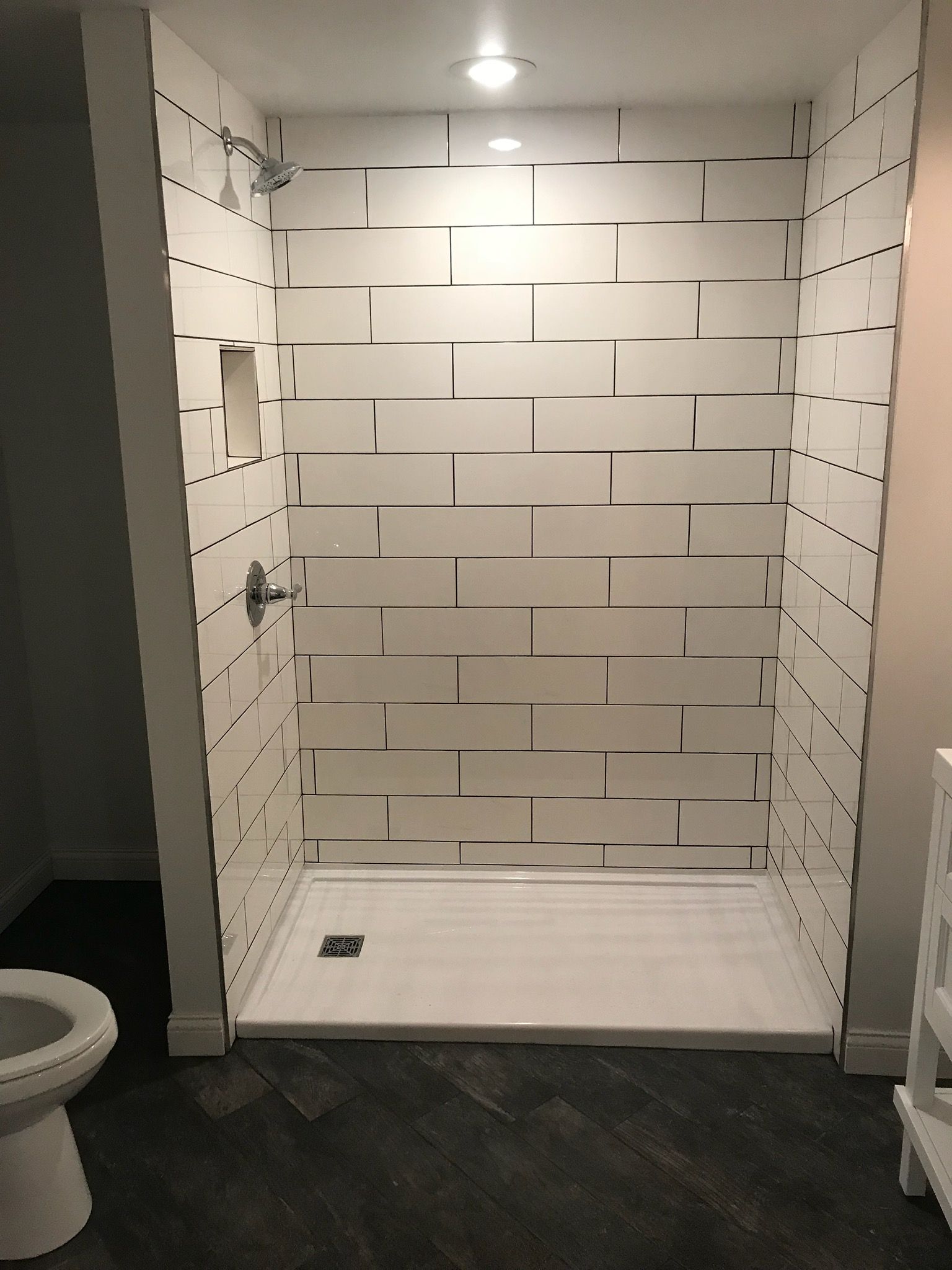 A bathroom with a walk in shower and a toilet.