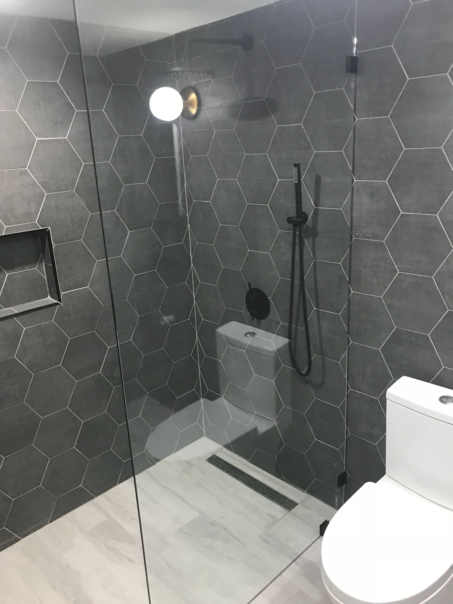 A bathroom with a toilet and a walk in shower.