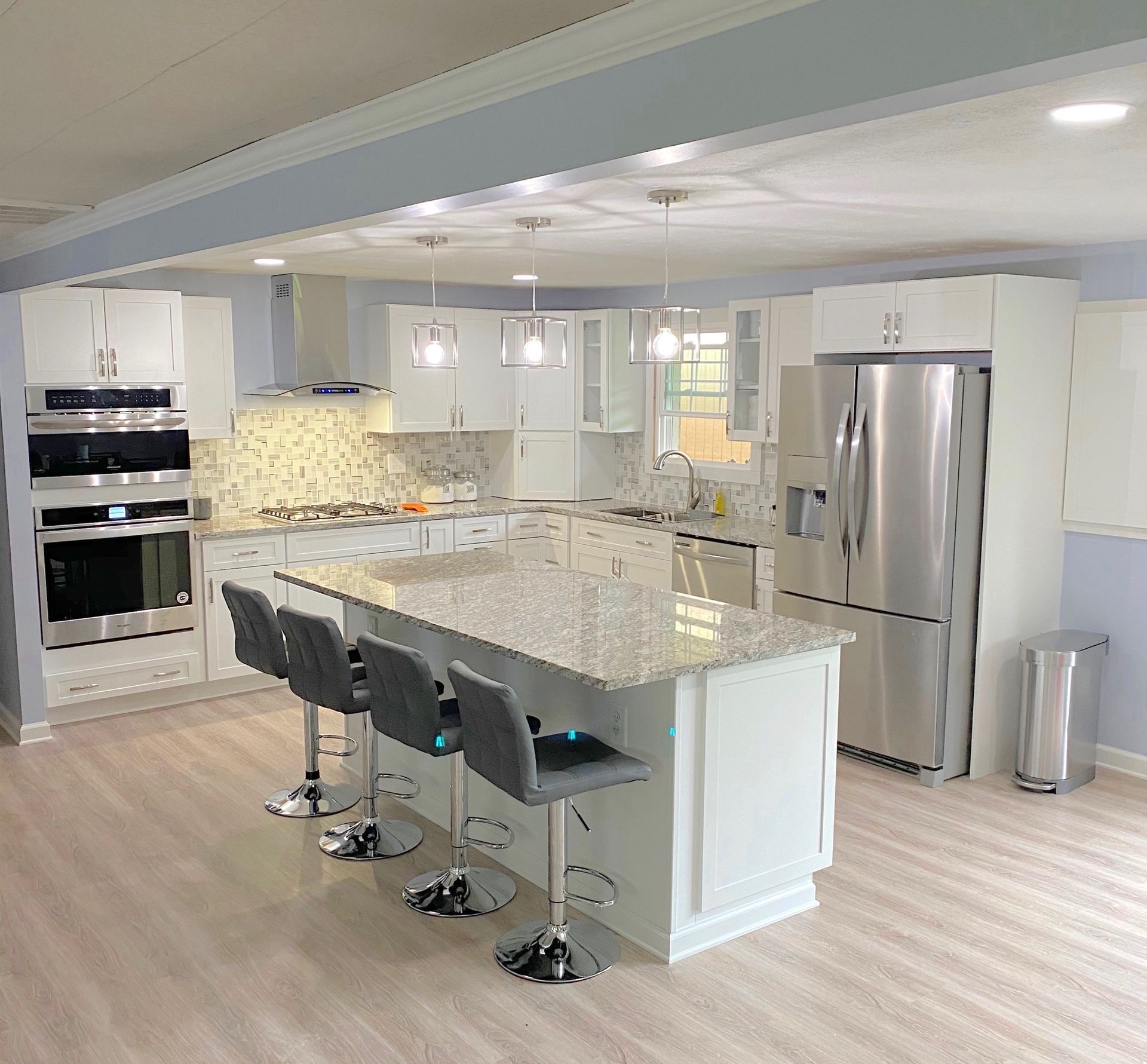 An empty room with a large window and a chandelier.