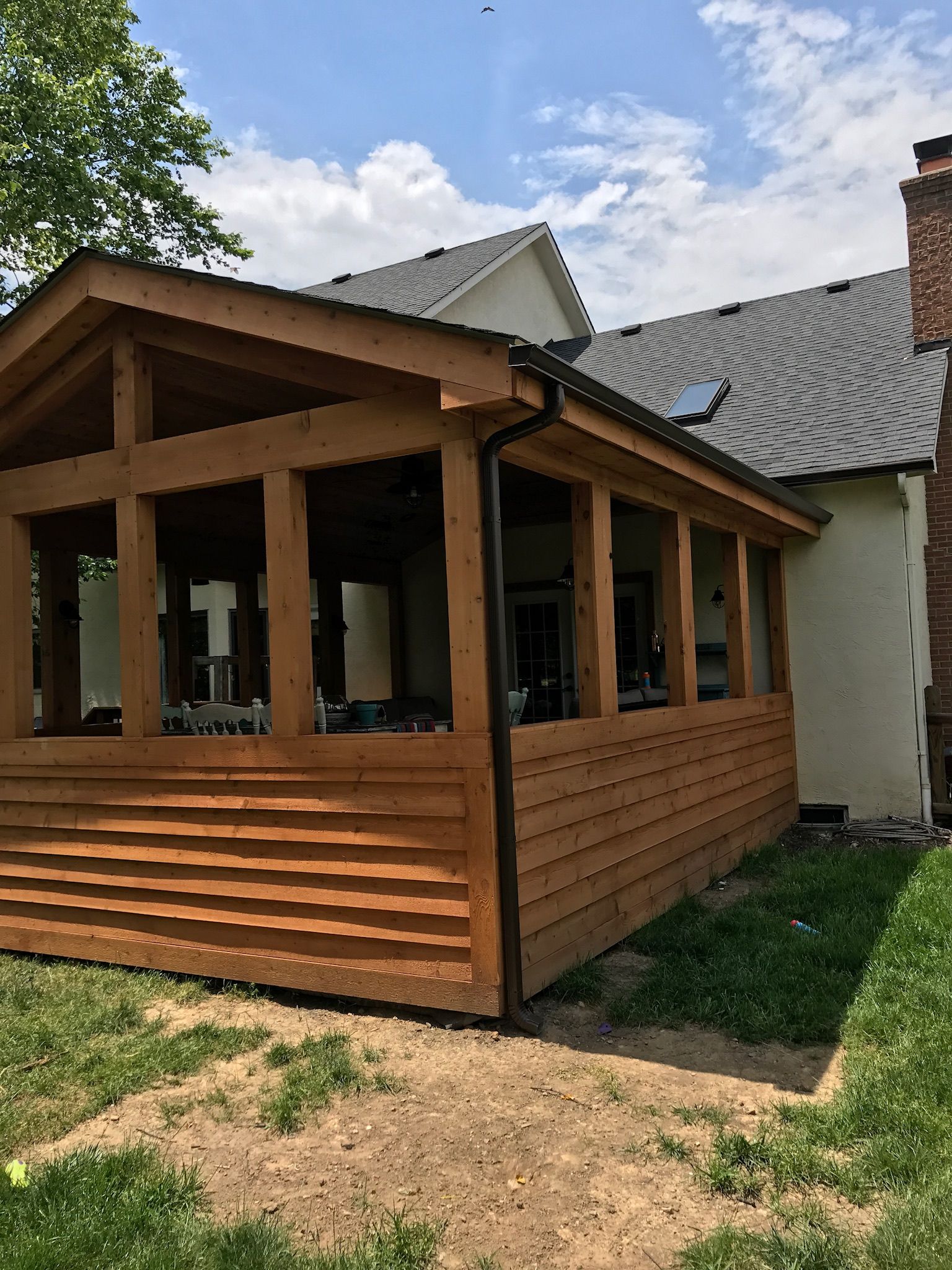 A wooden porch is sitting in front of a house.