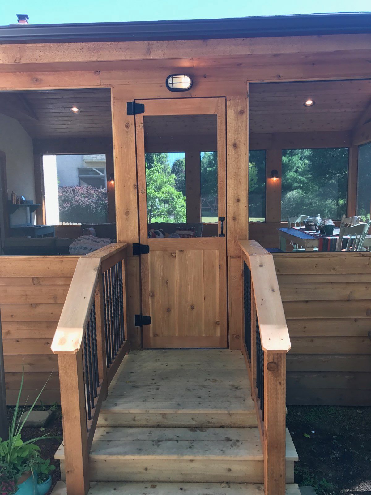 A screened in porch with a wooden door and stairs.