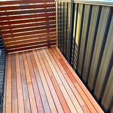 A Wooden Deck With a Fence in the Background — Illawarra Gardening Landscapes in Blackbutt, NSW